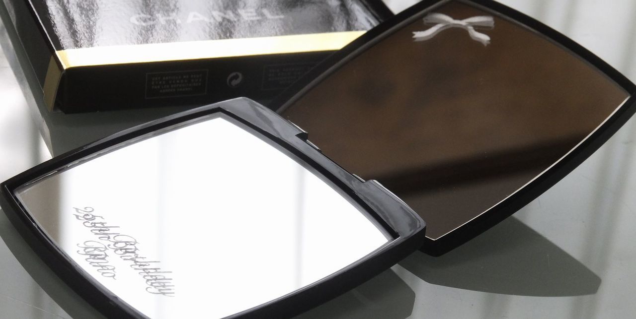 シャネルのミラー下部に、流麗なスクリプト体で『25th Birthday Rino』と名入れ彫刻が施された写真。自分だけの特別感を演出する、繊細でエレガントなパーソナルギフトのイメージ。