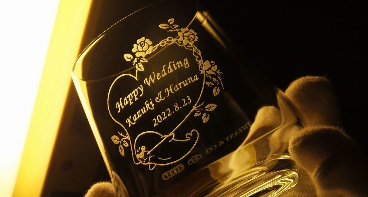 ティファニーの1837タンブラーの側面に、お持込みデザインと『Happy Wedding Kazuki&Haruna 2022.8.23』と名入れ彫刻した写真。エレガントなフォルムのタンブラーに、お二人だけの特別なオリジナルデザインと、結婚を祝うメッセージと名前、そして記念日が丁寧に刻まれています。世界に一つだけの特別な結婚祝いの贈り物です。