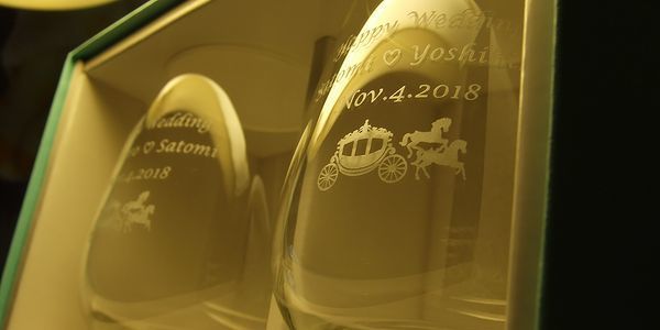 ティファニータンブラーの側面に、Happy Weddingのメッセージとお二人の名前、記念日を名入れ彫刻。新郎新婦を乗せた馬車のデザインが添えられた、上品でロマンチックな結婚祝いギフト