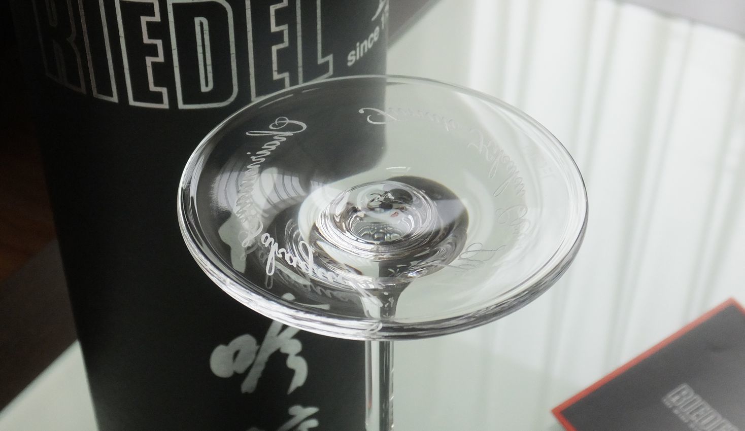 リーデル（RIEDEL）の『大吟醸』グラスの底面に、会長（チェアマン）就任祝いとして格調高い名入れ彫刻を施した写真。大吟醸酒のフルーティーな香りと爽やかな味わいを引き出すために作られた卵型の美しいクリスタルガラスの底面に、新たな最高責任者の就任を祝う文字が精緻に刻まれており、日本酒を愛するリーダーへの最大の敬意とこれからのさらなる繁栄の願いを伝える、世界に一つだけの特別な法人ギフトのイメージ。