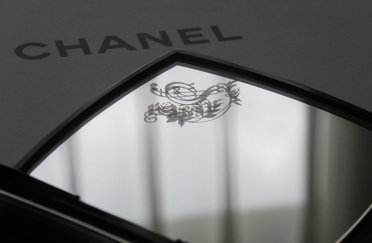 シャネルのコンパクトミラーの上部ミラー左上に、イニシャル『S』がバラで装飾され美しく名入れ彫刻された写真。シンプルながらもブランドの高級感を引き立てる、洗練されたパーソナライズデザインのイメージ。 glad there is Yuka』と名入れ彫刻を施した写真。大切な人への感謝や愛情を伝える、パーソナルで心温まるギフトの細部が際立っています。