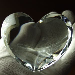 手のひらに乗せられたバカラのザンザンハート〈クリア〉。透き通るクリスタルが繊細に輝き、愛や感謝を伝える高級感あふれる贈り物としての存在感を放つ