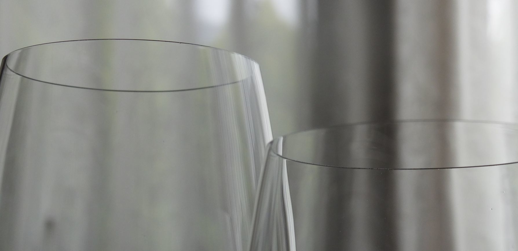 リーデル（RIEDEL）の『オー・シリーズ』大吟醸グラスの口元を捉えたクローズアップ写真。日本酒の繊細な風味をダイレクトに届けるために極限まで薄く仕上げられた、滑らかで精緻なリム（飲み口）のラインが特徴。クリスタルガラスの純粋な透明感と、熟練の技術を感じさせる美しい曲線が際立つ、最高級の酒器の質感を表したイメージ。