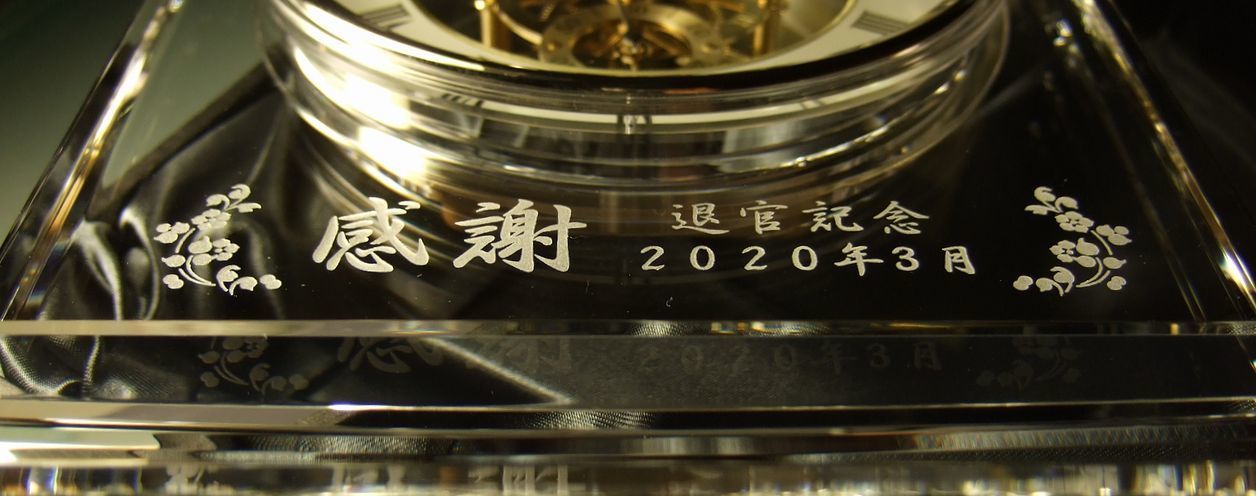 グラスワークスナルミのマルカートスケルトンクロックに『感謝』の文字と日付をお花のデザインで囲い彫刻した退職祝いの名入れ時計