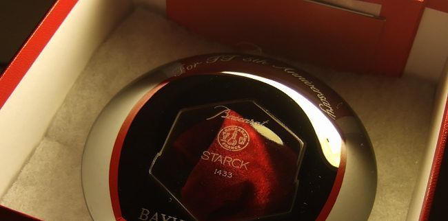 バカラのベビーキャンドルホルダー〈アワファイヤー〉の底面に周年記念、お名前、会社名を名入れ彫刻した特別な記念品。透明感のあるクリスタルがキャンドルの灯りを優しく反射し、贈り物としての高級感を際立たせる