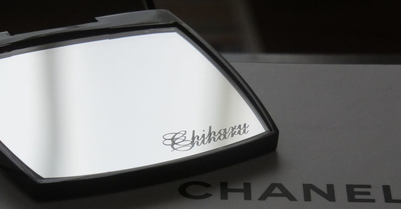 シャネルのミラー下部に、流麗なスクリプト体で『chiharu』と名入れ彫刻が施された写真。自分だけの特別感を演出する、繊細でエレガントなパーソナルギフトのイメージ。