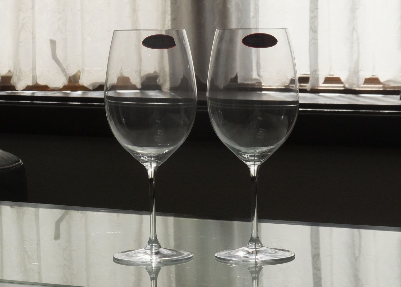 テーブルの上に置かれた、リーデル（RIEDEL）のヴィノム ボルドー・グラン・クリュのペアグラス。大きなボウルと細身のステムが美しい、赤ワインの芳醇な香りを引き出す最高級のクリスタルグラスが並ぶ、優雅なテーブルセッティングのイメージ。