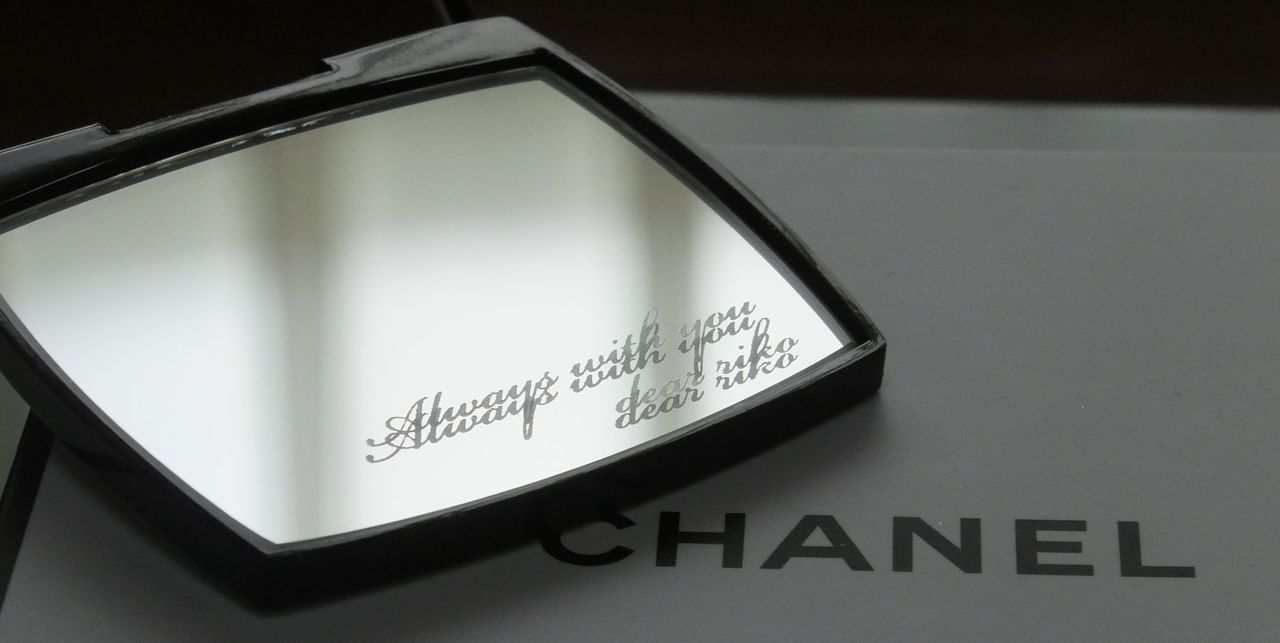 シャネルのミラー下部に『Always with you dear riko』とメッセージが名入れ彫刻された写真。大切な人への想いを込めた英文と名前が刻印された、心温まるパーソナライズギフトのイメージ。