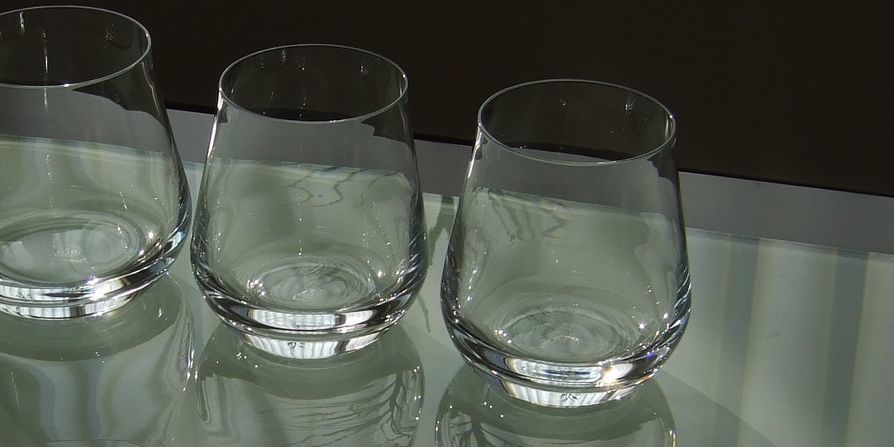 バカラのタンブラー（ロックグラス）の名入れページの商品一覧で使用する写真。バカラ シャトータンブラーSのペアグラスがテーブルの上に置かれています。丸みを帯びた美しいフォルムと、光を反射して輝くクリスタルが、ペアギフトとしての優雅さと特別感を演出しています。