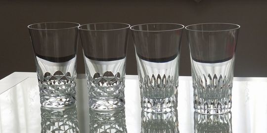 バカラグラスの商品紹介写真：スウィングハイボールとヴィータハイボールが4脚、テーブルの上に横一列に美しく並べられた写真。それぞれのグラスの異なる表情と、バカラのクリスタルが放つ輝きが際立つレイアウトです。