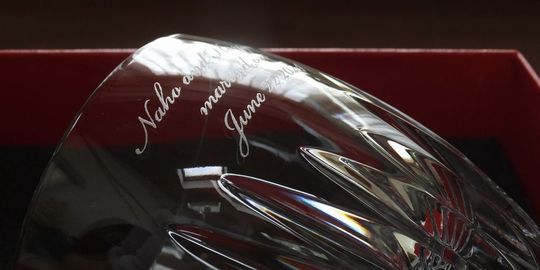 バカラのタンブラー（ロックグラス）の名入れページの商品一覧で使用する写真。バカラ マッセナタンブラーの側面に、結婚祝いの二人の名前と日付などを名入れ彫刻した写真。重厚なカットが施されたクリスタルに、愛を誓うお二人の大切な情報が美しく刻まれています。特別な日の贈り物として、仙台で贈る洗練された記念品です。