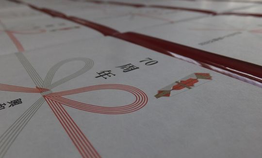 バカラのブランドボックスがバカラ専用包装紙で包まれ、70周年記念の熨斗が付けられた高級ギフトの写真 記念品や企業向け贈答品として最適なラグジュアリーな包装事例