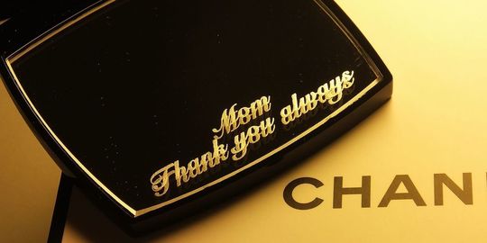 母の日のプレゼントに最適な、シャネルのコンパクトミラーに『Mom Thank you always』と名入れ彫刻を施したアップ写真。感謝の気持ちを伝える、パーソナルで心温まるギフトの細部が際立っています。
