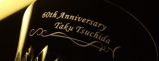 バカラのタンブラーの側面に還暦祝いのメッセージとお名前、装飾デザインが名入れ彫刻された、特別な60歳の誕生日を祝う高級クリスタルギフト。エレガントで洗練されたデザインが還暦の記念日を華やかに演出します