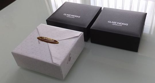 グラスワークスナルミの時計がギフトボックスに入れられ、包装紙に包まれた状態の写真。丁寧に包まれたギフトが、贈る人と受け取る人に特別な体験を提供する予感を感じさせる