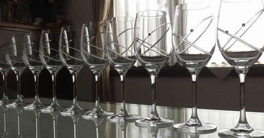 ウェッジウッド プロミシスウィズディスリングのワイングラスがテーブルの上に多数並べられた写真。結婚祝いや記念品として、複数個をまとめて贈る際のイメージを伝えるレイアウトです。