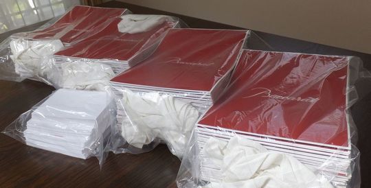 バカラのショッパーが10枚ずつ束ねられた4束がビニール袋に丁寧に梱包され、メッセージカードも個別に保護された写真 高級ギフト用付属品の整然とした発送準備事例