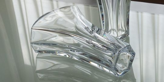 その他バカラの商品紹介写真：テーブルの上に置かれたバカラの花瓶、ギンコ。銀杏の葉をモチーフにした美しいデザインと、クリスタルの透明感が際立ち、空間に優雅さを添えるレイアウトです。