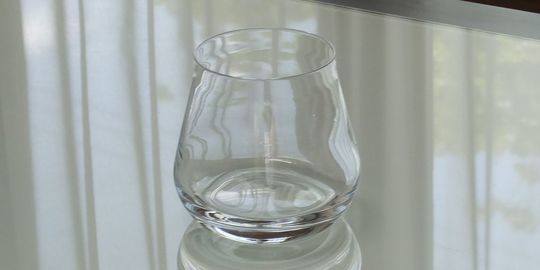 バカラのタンブラー（ロックグラス）の名入れページの商品一覧で使用する写真。バカラ シャトータンブラーがテーブルの上に置かれています。丸みを帯びた美しいフォルムと、光を反射して輝くクリスタルが、名入れギフトとしての優雅さと特別感を演出しています。