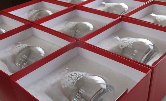 30周年記念ロゴデザインを名入れ彫刻したバカラのシャトータンブラーがレッドボックスに入った写真。大口の高級記念品のギフト事例