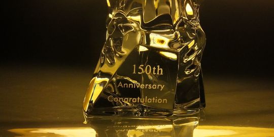 バカラのアメリカンイーグルの台座に、『150th Anniversary Congratulation』と名入れ彫刻した写真。力強い鷲のオブジェの台座に、150周年を祝うメッセージが繊細に刻まれています。企業の歴史と偉業を称える特別な贈り物となります。