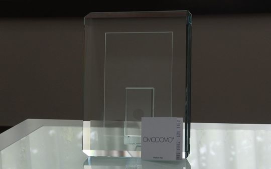 OMODOMO（オモドモ）のフォトフレーム『コントラ』がテーブルの上に置かれた写真。エクストラクリアガラスの透明感と重厚感、イタリアンデザインが魅力