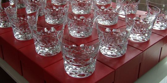 レッドボックスの上に美しく並べられた大量のバカラロックグラスの写真 高級感溢れるバカラグラスのギフトセット、大口注文の贈答品や記念品に最適なパッケージング事例
