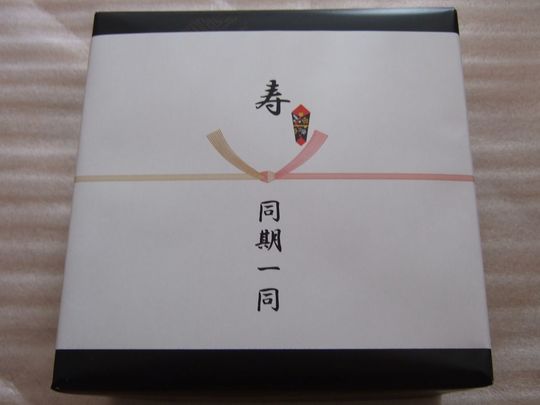 リーデルのブランドボックスが上品な包装紙で包まれ、熨斗をかけた高級ギフトの写真 公式ラッピングと熨斗対応による法人向け・記念品向け贈答品の事例