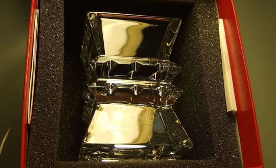 バカラのコロンビーヌベースがレッドボックスに入っている写真。ピラミッドのような建築がが特徴の花瓶が、バカラの象徴的な赤い箱に収められ、贈り物としての高級感と特別感を際立たせています。