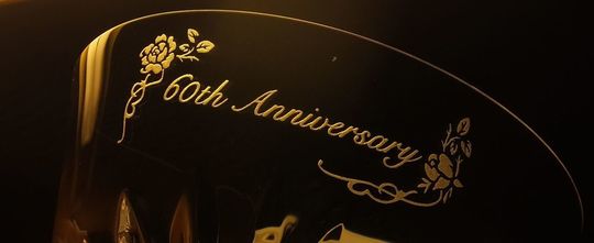 バカラのタンブラーの側面に還暦祝いのメッセージとエレガントな装飾デザインが名入れ彫刻された、特別な60歳の誕生日を祝う高級クリスタルギフト。洗練されたデザインが還暦の記念日を華やかに演出します