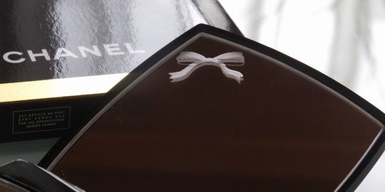 シャネルのコンパクトミラーに、リボンのデザインを名入れ彫刻した写真。シャネルの象徴的なデザインに、可愛らしいリボンのデザインが丁寧に刻まれています。女性への特別な贈り物や、誕生日・記念日のギフトに最適な逸品です。