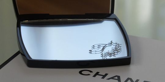 シャネルのコンパクトミラーに彫刻されたイニシャルデザインが、シンプルながら上品な印象を与える。どんなギフトシーンでも特別な思いを伝えることができます