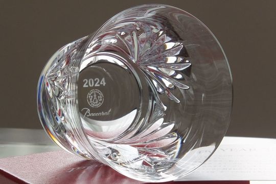 バカラのイヤーグラスを横に倒してレッドボックスの上に配置した美しい写真。高級感あふれるデザインが際立つ