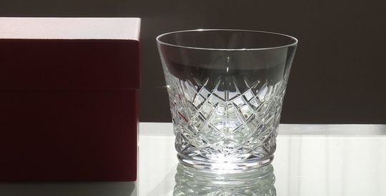 バカラのイヤータンブラー〈アリア2025〉とレッドボックスを並べた写真。贈り物として最適な輝きを放ち、結婚祝い、誕生日、記念日などのお祝いに相応しい特別感を演出しています
