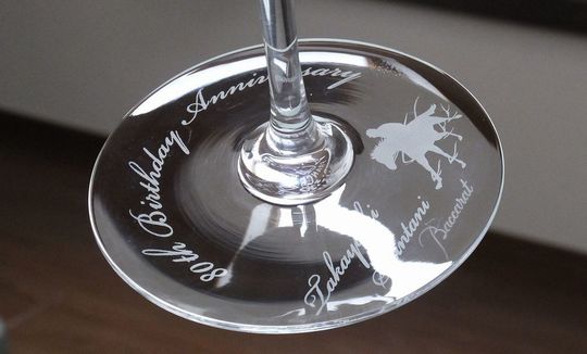 バカラのワイングラスの底面に「80th Birthday Anniversary」の文字とお名前が名入れ彫刻され、ジョッキーと競走馬のシルエットが描かれた特別な贈り物。80歳の誕生日を祝う豪華で個性的なデザイン