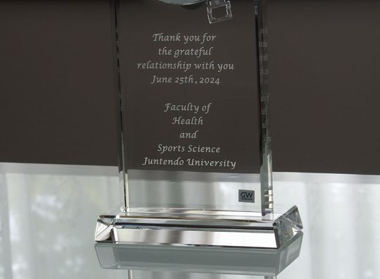 グラスワークスナルミのセレナペンドラムクロックに名入れ彫刻を施した記念品。順天堂大学の健康科学部とスポーツ科学部からの贈り物