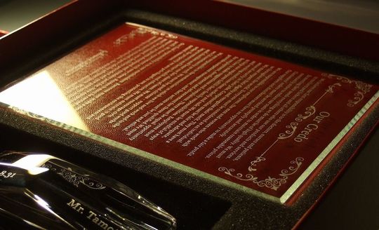 名入れ彫刻が施されたバカラ製アビスフォトフレーム。上部に『Our Credo』のタイトル、下部に英語の長文メッセージを精緻に刻印