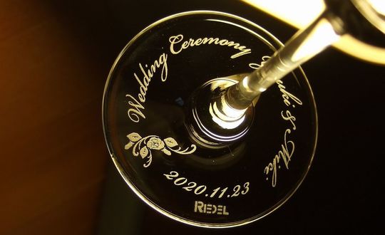 リーデル ヴィノムシリーズの底面に名入れ彫刻を施した写真。結婚祝い、名前、記念日、フラワーデザインを加えたオーダーメイドギフト。リーデルの高品質なワイングラスで、特別な記念日を祝う贈り物に最適