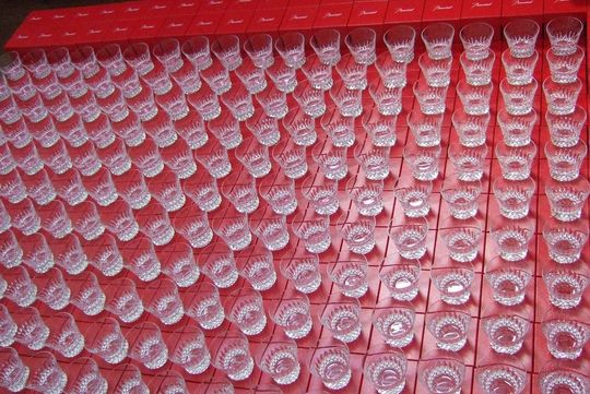 バカラのロックグラスがレッドボックスの上に100個以上並んだ写真 大量注文対応の高級名入れグラスギフトのイメージ