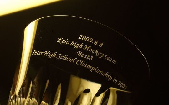 慶應ハイホッケーチームのインターハイベスト8進出記念として名入れ彫刻を施したバカラ製グラス。高校スポーツの栄誉を讃えるオーダーメイド記念品