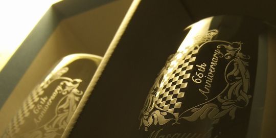 ウェッジウッド シークインビアグラスの側面に、王冠とチェッカーフラッグの千鳥模様のエンブレムの中に『65th Anniversary』と名入れ彫刻を施した写真。特別な記念を祝う、スタイリッシュなビアグラスです。