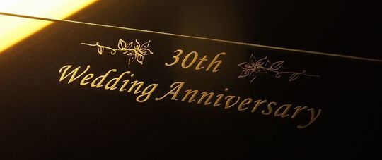 結婚30周年（真珠婚式）のお祝いに、フォトフレームへ「30th Anniversary」の文字と上品な装飾デザインが名入れ彫刻された写真