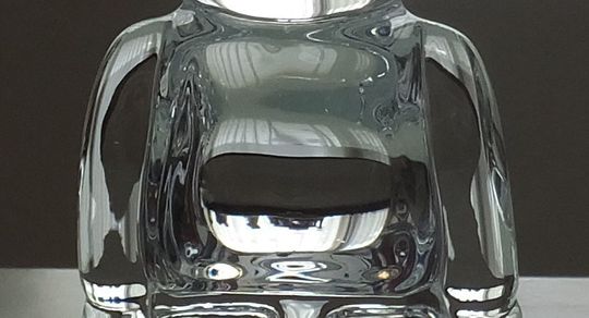 バカラのベアブリックの背中のアップ写真。透明なクリスタル製のベアブリックの背面がクローズアップされており、クリスタルガラスの滑らかな質感と、背中に施される名入れ彫刻のスペースがよく分かります。