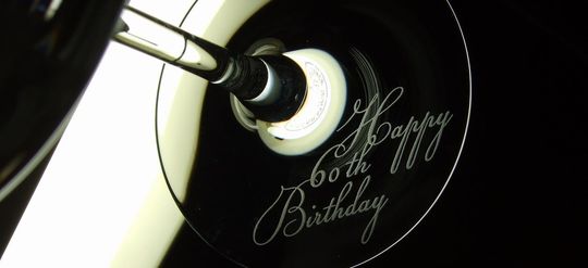 シャトーバカラワイングラスの底面に、スクリプト体で「Happy 60th Birthday」と名入れ彫刻されたクローズアップ写真：還暦祝いの特別なギフト