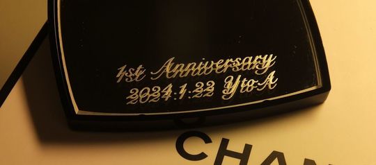 シャネルのコンパクトミラーに「1st Anniversary」の文字とお二人のイニシャル、記念日を名入れ彫刻した特別な1周年記念ギフト。高級感あふれるデザインで、二人の思い出を美しく刻む贈り物です