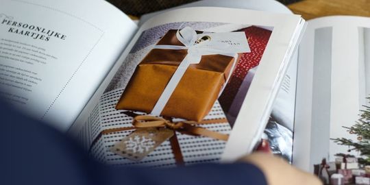 カタログギフトの本を開いて、中の商品を見ている写真