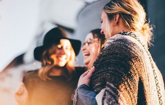 笑顔でほほ笑む中年の女性３人。心を潤してくれる仲間との絆を感じる瞬間。思い出として心に残る、名入れが与える特別な価値を象徴する写真