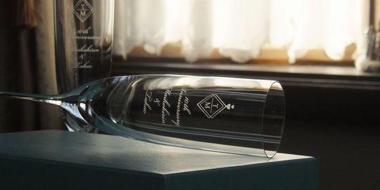 ティファニーのホームエッセンシャルシャンパングラスのペアの側面に、『10th anniversary』と二人の名前とイニシャルを名入れ彫刻した写真。エレガントなフォルムのグラスに、10周年を祝うメッセージと、二人の名前とイニシャルが丁寧に刻まれています。大切な二人の結婚記念日を祝う、心に残る特別な贈り物です。