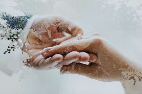 結婚式で男性が女性の手を優しく引いているシーンの手元を拡大した写真。新郎新婦の絆とぬくもりが伝わる、感動的でロマンチックな瞬間をとらえたウェディングフォト