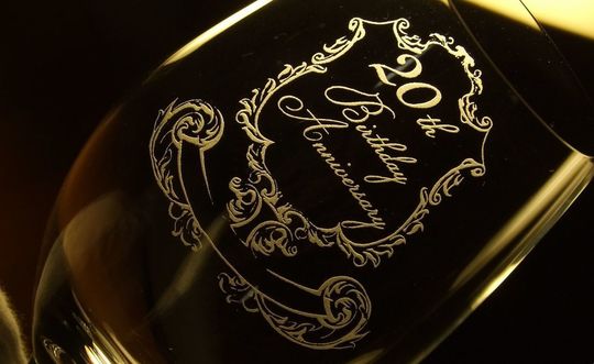 リーデルのホワイトワイングラスの側面にアンティーク調のフレームデザインと「20th Birthday Anniversary」の文字が名入れ彫刻された、特別な誕生日を祝う高級クリスタルギフト。エレガントでクラシカルなデザインが誕生日を華やかに演出します